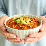Woman holding bowl of delicious chili