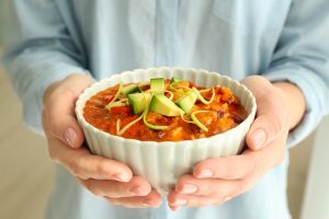 Woman holding bowl of delicious chili